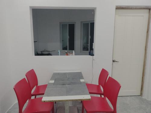 a dining room with a table and red chairs at Bais City Home Staycation in Bais
