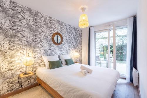 a bedroom with a large white bed with a wall at La Bohème in Montévrain