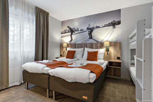 a bedroom with a large bed with a painting on the wall at First Camp Moraparken Hotel in Mora