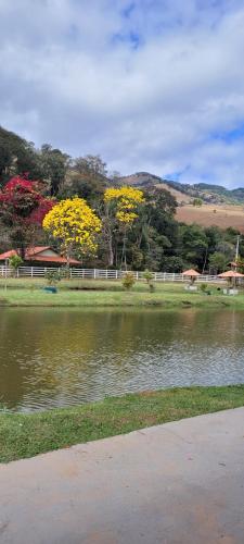 une masse d'eau avec des arbres à l'arrière-plan dans l'établissement Chalé Mantiqueira, à Piranguçu