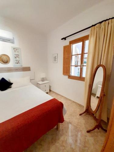 a bedroom with a bed and a mirror and a window at Casa El Rafal in Porreres