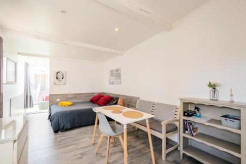a bedroom with a bed and a table and chairs at Chanot Le Studio cour parking et piscine in Marseille
