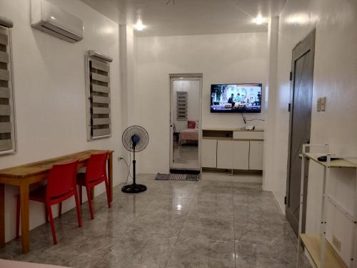 a living room with a table and chairs and a television at Bais City Home Staycation in Bais