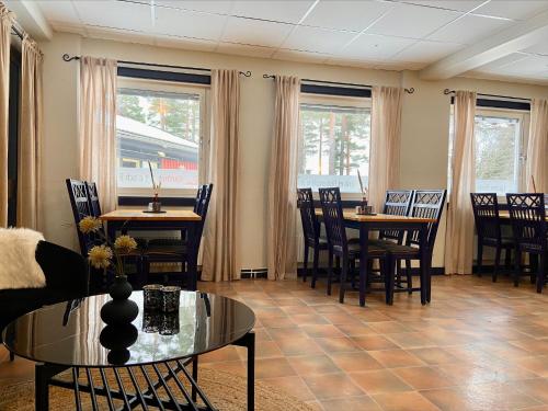 a living room with tables and chairs and windows at First Camp Moraparken Hotel in Mora