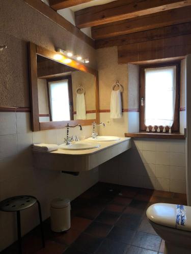 a bathroom with a sink and two mirrors and a toilet at Posada Real Mingaseda in Navafría