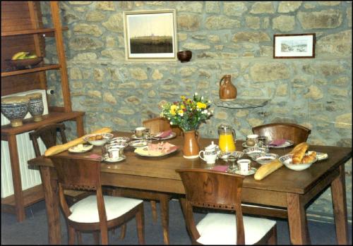 - une table en bois avec de la nourriture dans l'établissement La Goëlette, à Saint-Suliac
