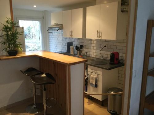 - une petite cuisine avec un comptoir et des tabourets dans l'établissement Studio fond de jardin, à Palaiseau