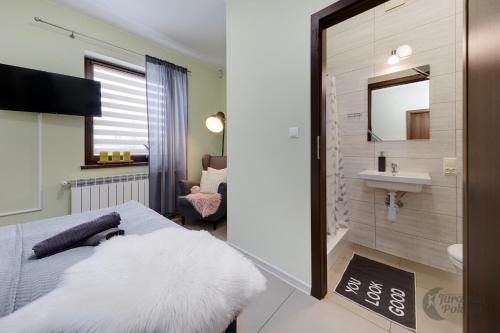 a bedroom with a bed and a sink and a mirror at Jurajska Pokusa in Kroczyce