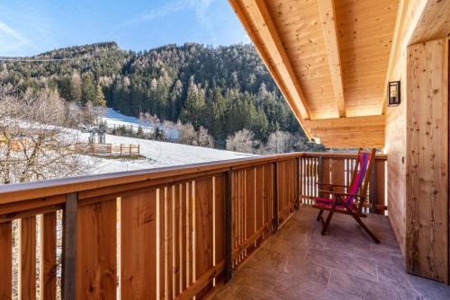 a rocking chair on a balcony with a view at Balbeinhof Apt Gams in Luson