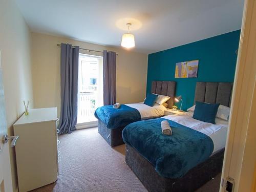 um quarto de hotel com duas camas e uma janela em Ground Floor Apartment Private Parking Sleeps 5 near City Centre and Shopping Centre em Birmingham