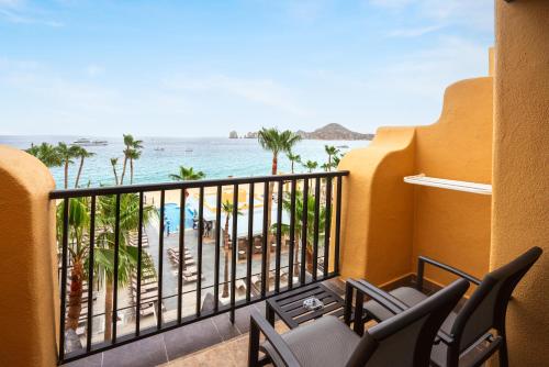 a balcony with chairs and a view of the beach at Riu Santa Fe - All Inclusive in Cabo San Lucas