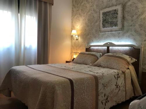 a bedroom with a large bed and a window at Hotel Macavi Playa in Rota