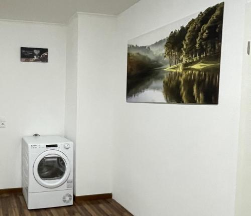 a washing machine in a room with a painting on the wall at 4-Zimmer Wohnung in Wuppertal 6 Personen in Wuppertal