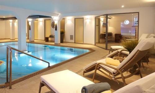 a swimming pool in a hotel with lounge chairs at Inselresidenz Strandburg Juist - Wohnung 107 (Ref. 52044) in Juist