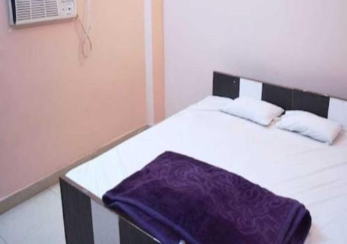 ein Schlafzimmer mit einem Bett mit einer lila Decke darauf in der Unterkunft Hotel M. S. Palace By WB Inn in Agra