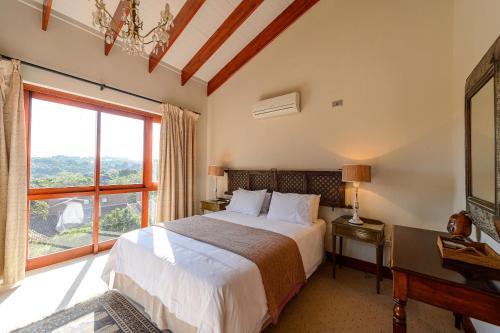 Un dormitorio con una cama y una ventana grande en San Lameer Villa 5910 - 4 Bedroom Luxury - 8 pax - San Lameer Rental Agency, en Southbroom