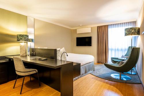 Habitación de hotel con cama, escritorio y sillas en Holiday Inn Hotel Brussels Airport, an IHG Hotel en Diegem