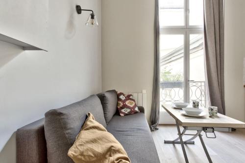 un salon avec un canapé et une table dans l'établissement Studio Vivienne - Welkeys, à Paris