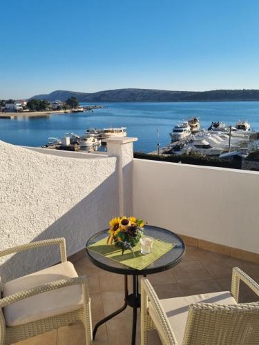 d'un balcon avec une table et des chaises et une vue sur le port de plaisance. dans l'établissement Leut, à Barbat na Rabu