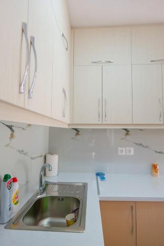 a kitchen with a sink and white cabinets at Villa All Season in Sarandë