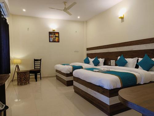 a hotel room with two beds and a table at Green Club Farm in Ajmer