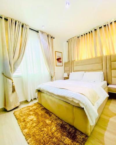 a bedroom with a large bed and a large window at Lovely 2 bedroom in ikate in Lekki