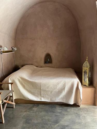 a bedroom with a bed and a table and a lamp at Dammusi IL SERRALH -Pantelleria- in Pantelleria