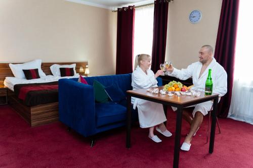 a man and woman sitting on a couch in a hotel room at Premier Inn Astana in Astana