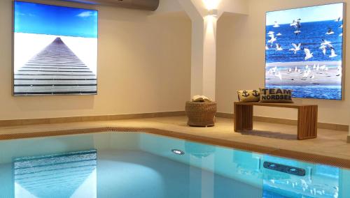 a swimming pool in a living room with a painting on the wall at Strandburg Juist - Turmwohnung 105 (Ref. 50957) in Juist