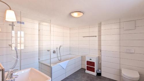 a bathroom with a tub and a sink and a toilet at Ferienwohnung Krause in Pfronten