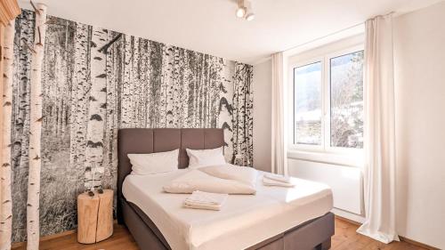 a bedroom with a bed with a black and white wallpaper at Chalet am Breitenberg Appartement CB 11 in Pfronten
