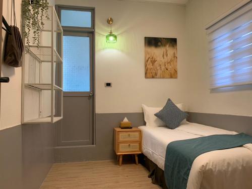 a small bedroom with two beds and a window at 金玉旅社 in Guanshan