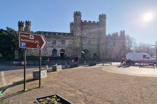 a sign in front of an old castle at The George Hotel in Battle