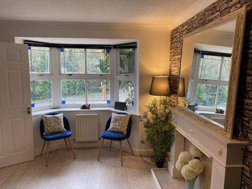 a living room with two chairs and a fireplace at Riverside in Kent