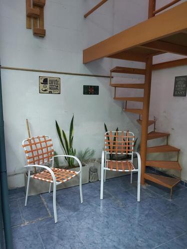 two chairs and a table and a staircase at Cerca de todo monoambiente in Buenos Aires