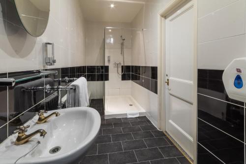 a bathroom with a sink and a shower at The George Hotel in Battle