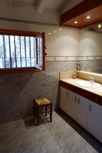 baño con lavabo, espejo y taburete en Mas de la Vall del Frare, en Gandesa