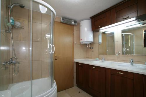 uma casa de banho com um chuveiro, um lavatório e uma banheira em Holiday Home Ametist em Kotor