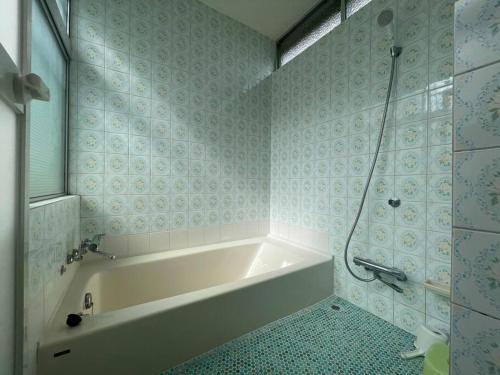a bathroom with a bath tub and a shower at ■屋根付BBQテラスのある貸別荘■1棟貸しなので安全安心■3台分の無料駐車場完備です in Izu
