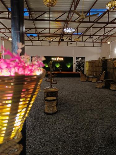 a large room with chairs and flowers in the middle at Green Club Farm in Ajmer