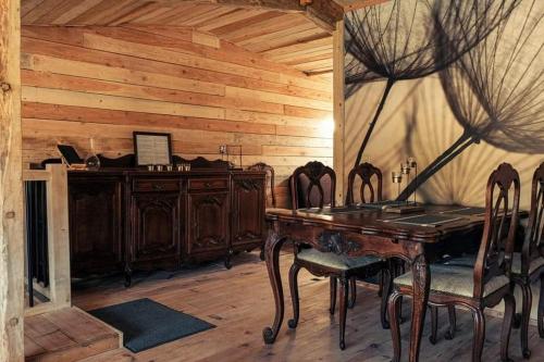 una sala da pranzo in legno con tavolo e sedie in legno di Le P'tit Nid : Mini loft pour 2 à 4 personnes a Tellin