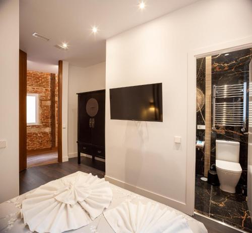 a bedroom with a large bed and a tv on a wall at San Bernardino 15 in Madrid