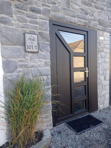 a door to a stone building with a sign on it at Le P'tit Nid : Mini loft pour 2 à 4 personnes in Tellin