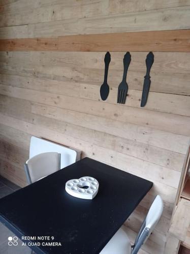 a black table with utensils hanging on a wall at Le P'tit Nid : Mini loft pour 2 à 4 personnes in Tellin