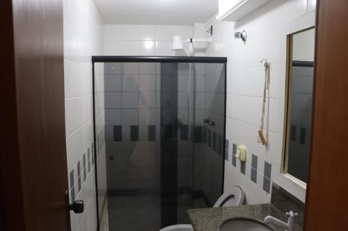 a bathroom with a shower with a toilet and a sink at Hotel Conceição da Barra in Conceição da Barra