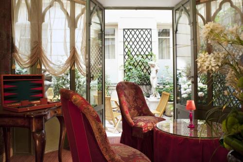 Cette chambre comprend un bureau, des chaises et une table. dans l'établissement Chambiges Elysées, à Paris