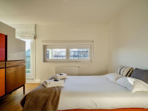 - une chambre avec un grand lit blanc et une fenêtre dans l'établissement Stijlvolle en lichtrijke design penthouse met prachtig uitzicht te Wenduine, au Coq