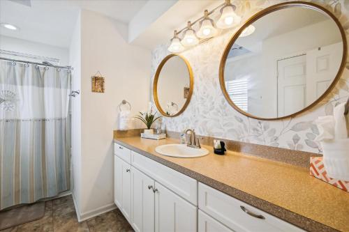 a bathroom with a sink and a mirror at Pelican Path in Galveston