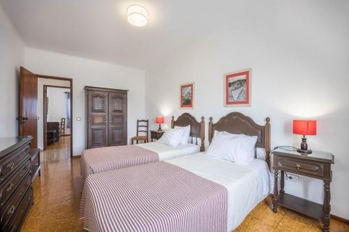 um quarto com 2 camas e uma mesa com candeeiros em Cabo de Sagres -2 bedroom apartment em Sagres