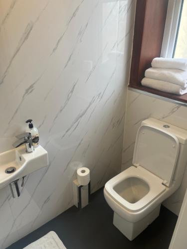 a bathroom with a white toilet and a sink at Shores Holiday Apartments in Blackpool